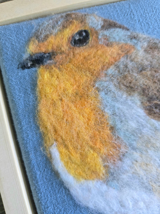 Needle felted artwork of a robin on a blue background
